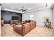 Spacious living room featuring hardwood floors, a comfy sectional sofa and a ceiling fan at 15818 Sparrowridge Ct, Charlotte, NC 28278