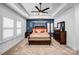 Bright main bedroom features a four-poster bed, complemented by white shutters, tray ceiling, and navy blue accent wall at 15818 Sparrowridge Ct, Charlotte, NC 28278