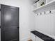 Functional mudroom with a gray door, coat hooks, cubbies, and a bench, providing an organized entry space at 15818 Sparrowridge Ct, Charlotte, NC 28278