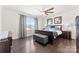 Spacious main bedroom featuring dark wood floors, a ceiling fan, and large windows at 16617 Cozy Cove Rd, Charlotte, NC 28278