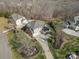 Aerial view of the home showcasing its well-maintained lawn, and brick/siding exterior with a three car garage at 182 Walking Horse Trl, Davidson, NC 28036