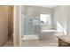 Bright bathroom featuring a glass-enclosed shower, soaking tub, and a neutral color palette at 182 Walking Horse Trl, Davidson, NC 28036
