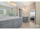 Elegant bathroom with double vanities, framed mirrors, modern lighting, and a glass-enclosed shower at 182 Walking Horse Trl, Davidson, NC 28036