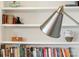 Close up of bookshelf with books, decor, and a modern lamp at 182 Walking Horse Trl, Davidson, NC 28036