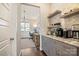 Well-appointed butler's pantry with custom cabinets, granite countertops, and coffee bar, leading to an office at 182 Walking Horse Trl, Davidson, NC 28036