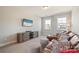 Inviting living room featuring a comfortable leather sofa, patterned ottomans and a wall-mounted TV at 182 Walking Horse Trl, Davidson, NC 28036