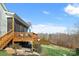 Back of the home with a wooden deck, screened porch, and a landscaped lawn at 182 Walking Horse Trl, Davidson, NC 28036