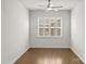 Bright bedroom featuring hardwood floors, a modern ceiling fan, and a window with white shutters at 2020 Canova Dr, Mount Holly, NC 28210