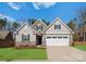 Charming home with stone accents, gray siding, well-manicured lawn, and a two-car garage at 2020 Canova Dr, Mount Holly, NC 28210