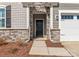 Inviting front entrance with stone archway, black front door, and well-maintained landscaping at 2020 Canova Dr, Mount Holly, NC 28210