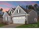 Home featuring a stone and siding exterior, two-car garage and well maintained lawn at 2020 Canova Dr, Mount Holly, NC 28210