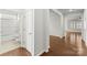 Bright hallway with wood floors leading to a bathroom and other rooms in the home at 2020 Canova Dr, Mount Holly, NC 28210