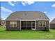 Charming rear exterior with gray siding, well-maintained lawn and screened in porch at 2020 Canova Dr, Mount Holly, NC 28210