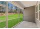 View from the screened porch featuring a lush green lawn and wooded landscape at 2020 Canova Dr, Mount Holly, NC 28210