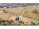 Aerial view of a modern farmhouse showing the landscaped lot surrounded by a wooded area at 2095 Tite Rd, Stanfield, NC 28163