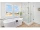 Modern bathroom featuring a standalone tub and luxurious marble-tiled shower with beautiful outdoor views at 2095 Tite Rd, Stanfield, NC 28163