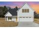 Beautiful exterior view of new construction home features a white facade, black trim, and attached two car garage at 2095 Tite Rd, Stanfield, NC 28163