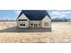 Charming new construction home featuring a sleek black roof, crisp white siding, and an inviting covered front entry at 2095 Tite Rd, Stanfield, NC 28163