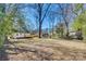 Expansive backyard featuring a wooden deck, partial fencing, and mature trees creating a private outdoor space at 2123 Purser Dr, Charlotte, NC 28215