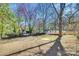 Spacious backyard with a wooden deck, partially fenced, and mature trees offering shade at 2123 Purser Dr, Charlotte, NC 28215