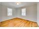 Cozy bedroom with hardwood floors, neutral walls, and two windows providing ample natural light at 2123 Purser Dr, Charlotte, NC 28215