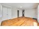 Neutral living room showcasing hardwood floors, closet and doorway leading to other rooms at 2123 Purser Dr, Charlotte, NC 28215