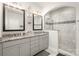 Bright bathroom with dual sinks, granite countertop, and glass-enclosed tiled shower at 234 Iverson Way, Charlotte, NC 28203