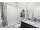 Well-lit bathroom featuring a shower-tub combo, granite vanity, and decorative wall shelves at 234 Iverson Way, Charlotte, NC 28203