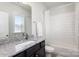 Clean bathroom with a combination tub and shower, granite vanity, and bright natural light at 234 Iverson Way, Charlotte, NC 28203