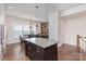 Kitchen island with granite countertop and dark wood cabinets, with a dining table in the background at 234 Iverson Way, Charlotte, NC 28203