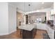 Kitchen island with granite countertop and dark wood cabinets, with a living room in the background at 234 Iverson Way, Charlotte, NC 28203