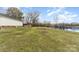 View of the back exterior with lake access, and a spacious yard with mature trees at 24697 Ramsey Dr, Albemarle, NC 28001