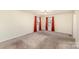 Spacious bedroom with plush carpet, two large windows with red curtains, and neutral walls at 24697 Ramsey Dr, Albemarle, NC 28001