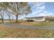 Rear of property with an attached garage, spacious yard, and gravel driveway at 24697 Ramsey Dr, Albemarle, NC 28001