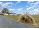Exterior of the home from a distance, showcasing the front lawn and driveway in a rural setting at 24697 Ramsey Dr, Albemarle, NC 28001