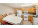 Bright kitchen featuring a peninsula with bar seating, white appliances, and light wood cabinetry at 24697 Ramsey Dr, Albemarle, NC 28001