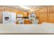 Kitchen featuring light wood cabinetry, white appliances, and expansive countertop space at 24697 Ramsey Dr, Albemarle, NC 28001
