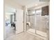 Walk-in shower featuring tiled walls, a glass door, and a view into the main bedroom at 253 Tackle Box Dr, Troutman, NC 28166