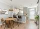 Open dining area with wood floors, a stylish light fixture, and access to the kitchen at 2658 Dilworth Heights Ln, Charlotte, NC 28209