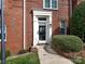 Close-up of the front door with a storm door, white trim, and manicured landscaping at 2658 Dilworth Heights Ln, Charlotte, NC 28209