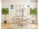 Sunlit dining room with a round table, six chairs, and decorative plants at 2810 Morning Song Way, Lancaster, SC 29720