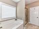 Bright bathroom featuring a soaking tub, a tiled shower, and a white door with a coat hook at 4130 Waterway Dr, Monroe, NC 28110