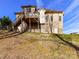 Exterior view showcasing a multi-level deck and brick facade of the home, set against a blue sky and grassy slope at 4130 Waterway Dr, Monroe, NC 28110