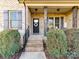 Charming front porch with brick steps and pillars, enhanced by lush greenery and decorative wreath on the door at 4130 Waterway Dr, Monroe, NC 28110