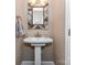 Powder room featuring pedestal sink with decorative mirror, and towel rack at 4130 Waterway Dr, Monroe, NC 28110