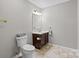 Neutral-toned bathroom with a single sink vanity and a toilet at 5902 Mt Holly Huntersville Rd, Charlotte, NC 28216