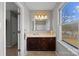 Bathroom featuring a vanity with dark cabinets and a window overlooking the yard at 5902 Mt Holly Huntersville Rd, Charlotte, NC 28216