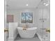Bright bathroom features a freestanding tub, glass shower, and a large window with natural light at 700 Queen Charlottes Ct, Charlotte, NC 28211