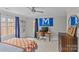 Spacious bedroom with fan and natural light, featuring desk and sports decor at 700 Queen Charlottes Ct, Charlotte, NC 28211