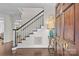 Elegant foyer showcases hardwood floors and a staircase with white railings and black accents at 700 Queen Charlottes Ct, Charlotte, NC 28211